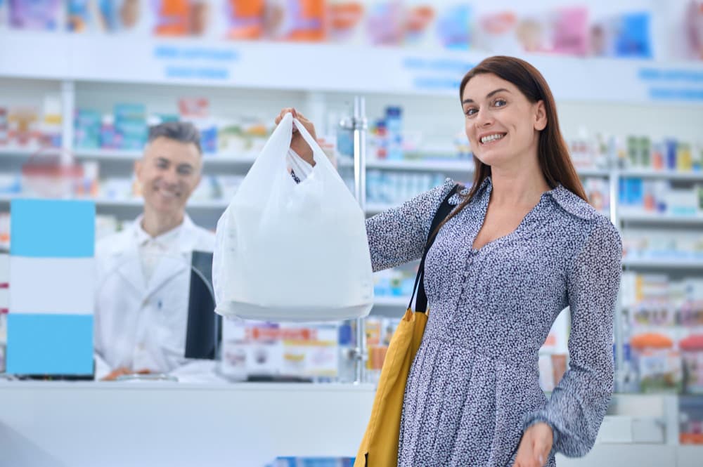 A woman standing with a collection of medicines
